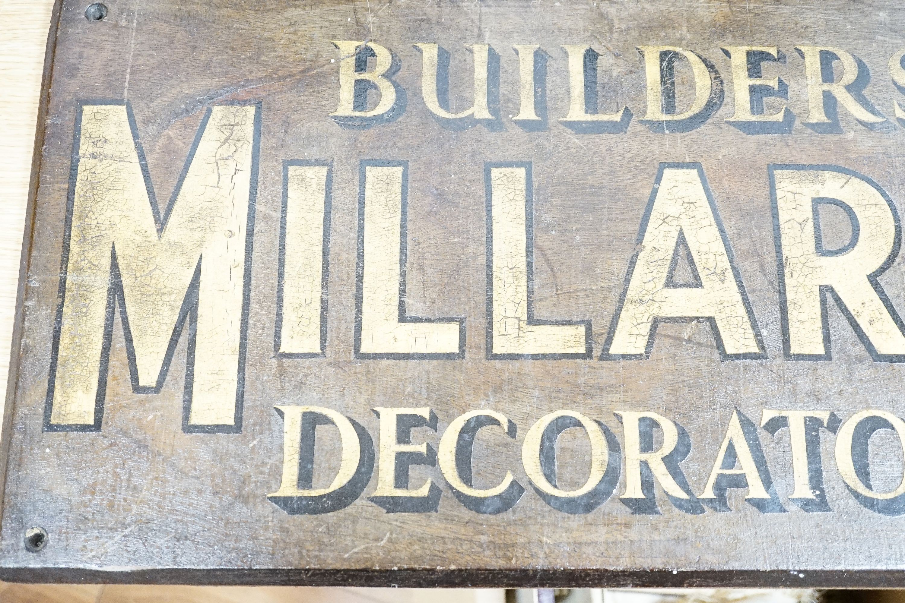 A painted wood advertising sign ‘MILLARDS BUILDERS DECORATORS’, pre war 33x67cm